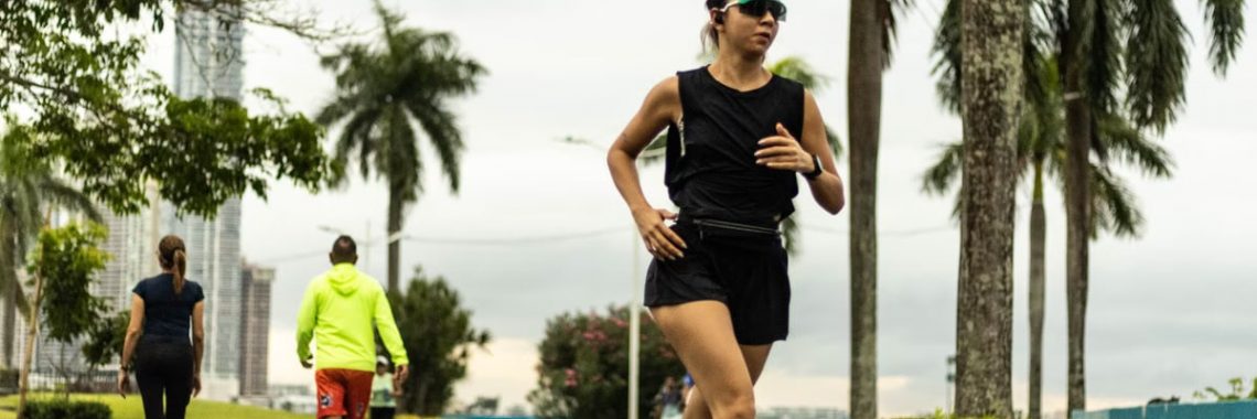 Woman jogging in a tropical park in Panama City on an overcast day.